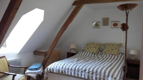 une chambre avec un lit dans un grenier dans l'établissement Les chambres des Demoiselles, à Beauval