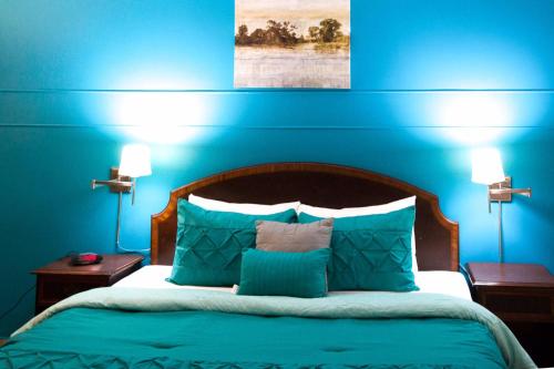 a blue bedroom with a bed with blue walls at Gables Inn in Miami