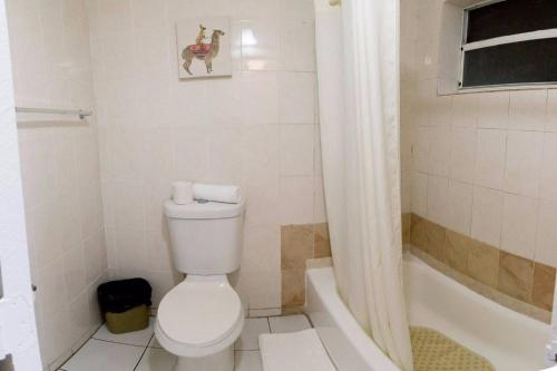 a bathroom with a toilet and a bath tub at Gables Inn in Miami