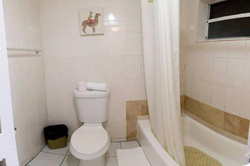 a white toilet sitting next to a bath tub at Gables Inn in Miami