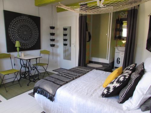 um quarto com uma cama com almofadas pretas e brancas em La Joliette em Junas