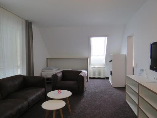 a living room with a couch and a table at Comfor Hotel Ulm City in Ulm