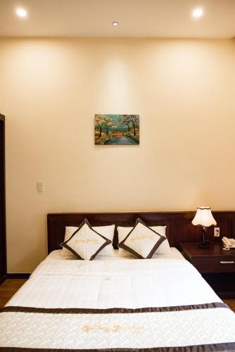 a bedroom with a large bed with white sheets at Spring Garden Villa in Hue