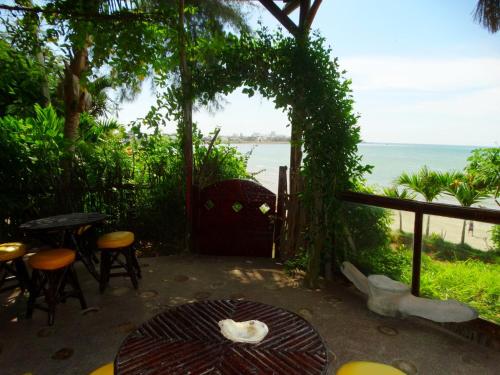 a patio with a table and chairs and a view of the ocean at Hostería Ecológica El Faro in Salinas