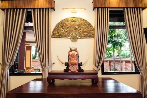 a statue in a room with two windows at Spring Garden Villa in Hue