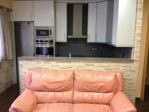 a brown leather couch in a kitchen with white cabinets at Apartamento Cala Blanca in Gandía