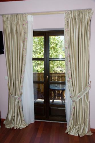a pair of curtains in front of a window at Hotel Monodendri in Monodendri