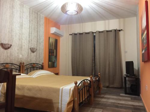 a bedroom with a bed and a television in it at Pomelo Apartments in Ayia Napa
