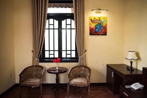 a room with two chairs and a table and a window at Spring Garden Villa in Hue
