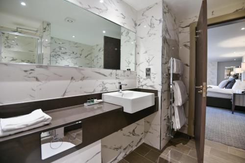 a bathroom with a sink and a mirror at Hetland Hall Hotel in Dumfries