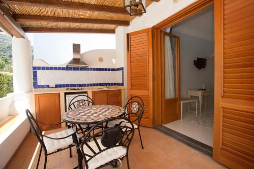 a dining room with a table and chairs on a balcony at Hotel Residence Mendolita in Lipari