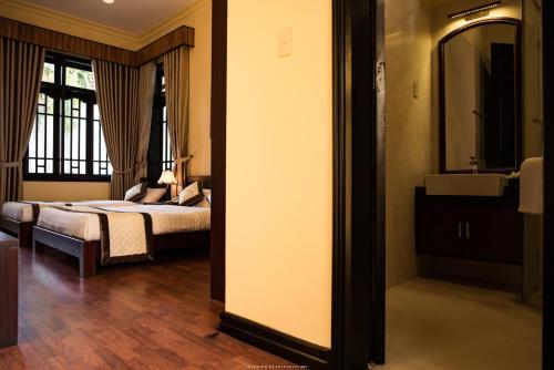 a bedroom with a bed and a sink and a mirror at Spring Garden Villa in Hue