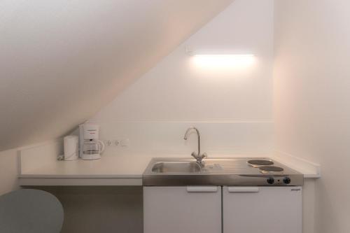 a kitchen with a sink and a counter top at Pension zum Schloss in Hamminkeln