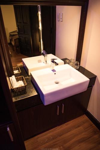 a bathroom with a white sink and a mirror at Spring Garden Villa in Hue