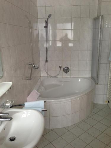 a bathroom with a bath tub and a sink at Gästehaus Maria in Garmisch-Partenkirchen