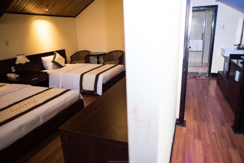a hotel room with two beds and a bathroom at Spring Garden Villa in Hue