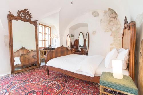 a bedroom with a bed and a large mirror at Chateau Třebešice in Kutná Hora