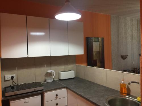 a kitchen with white cabinets and a sink at Pomelo Apartments in Ayia Napa