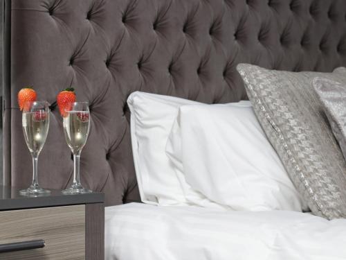 two glasses of champagne and strawberries on a bed at Hetland Hall Hotel in Dumfries