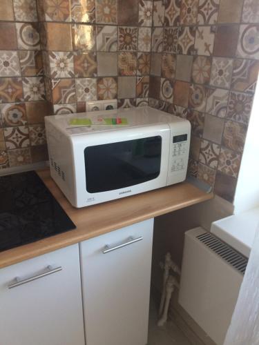 a microwave oven sitting on top of a counter at Apartment on 2-Y Khlynovskiy Pereulok 1 in Kirov