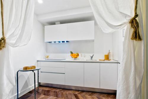 a kitchen with white cabinets and a sink at Gran Duca Sforza in Venice