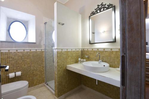 a bathroom with a sink and a toilet and a mirror at Casalta Di Pesa in Siena