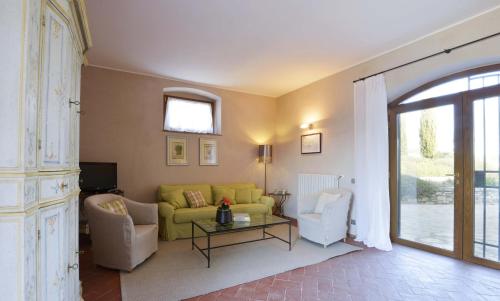 a living room with a yellow couch and two chairs at Casalta Di Pesa in Siena
