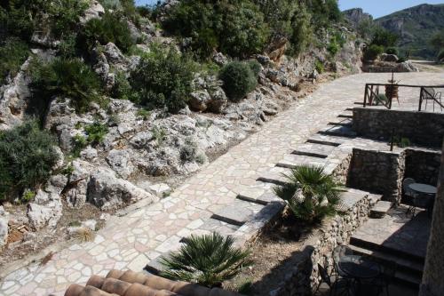 a stone pathway with plants on the side of a mountain at Casale Corcella in Scopello