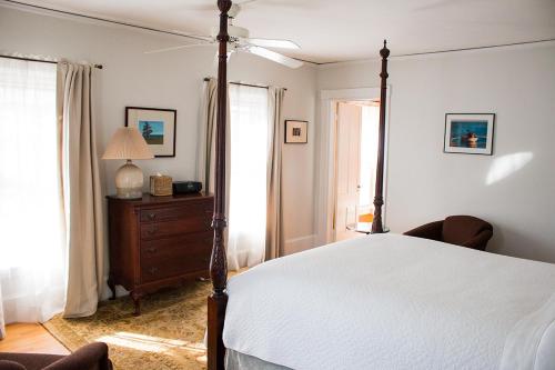 a bedroom with a bed and a dresser and windows at Camden Windward House in Camden