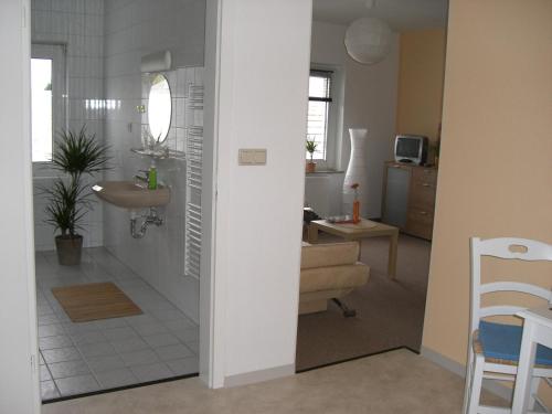 Zimmer mit einem Bad mit einem Waschbecken und einem Spiegel in der Unterkunft Zimmervermietung Schönfließer Stuben auch für Monteure in Eisenhüttenstadt