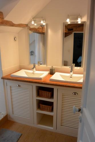 a bathroom with two sinks and two mirrors at Le Clos Millot in Beaune