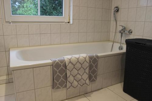 a bath tub with a towel on the side of it at Ferienhaus an der Grenze zu Hamburg Zentrale Lage in Neu Wulmstorf