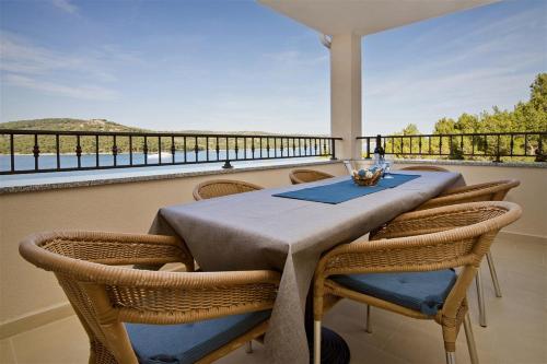 een tafel en stoelen op een balkon met uitzicht bij Apartment Obratov in Tisno