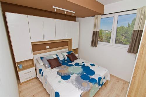 een slaapkamer met een groot bed in een kamer met ramen bij Apartment Obratov in Tisno