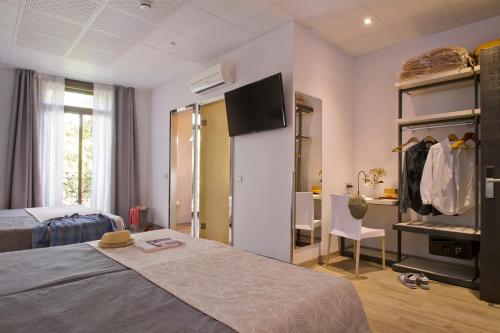 Habitación de hotel con cama y TV en Hostal Benidorm, en Barcelona