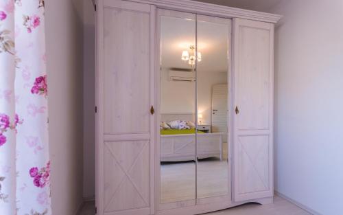 a sliding door with a mirror in a bedroom at Villa Mulberry in Krk