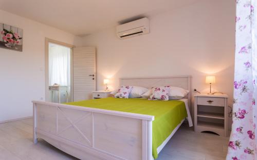 a bedroom with a large bed and two night stands at Villa Mulberry in Krk