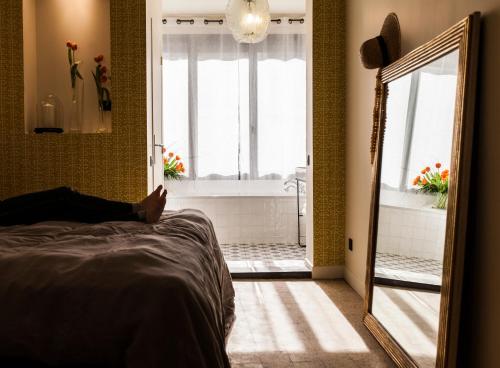 a person laying on a bed in a bedroom with a bathroom at Maison Volver in Arles