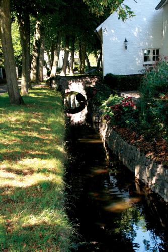 a stream next to a house next to a house at Fletcher Hotel La Ville Blanche in Thorn
