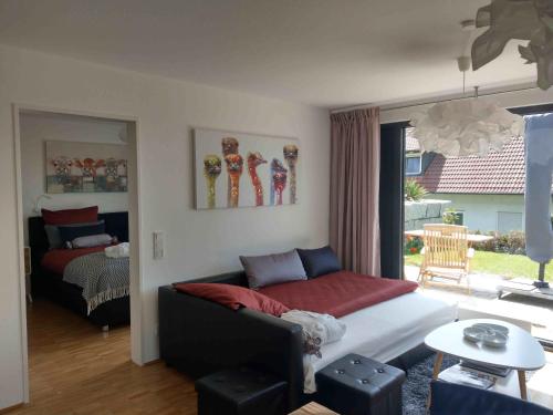 ein Wohnzimmer mit einem Sofa und einem Bett in der Unterkunft Panorama-Übernachtungen in Biberach-Ummendorf