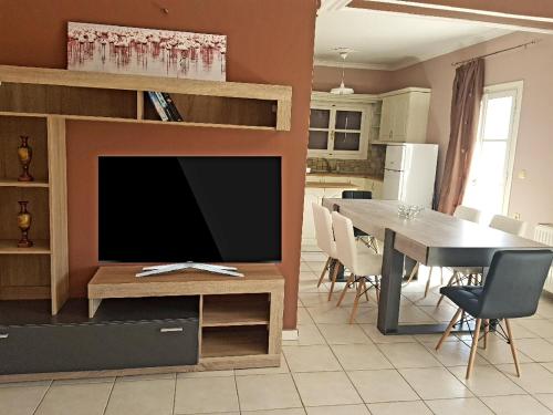 sala de estar con TV y mesa de comedor en Mojo modern apartment en Alikanas