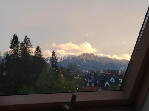 a window with a view of a city and mountains at Willa Pawlikowskich in Poronin