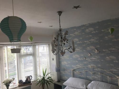 a bedroom with a mural of clouds and birds on the wall at Heavenly Retreat in Corsham