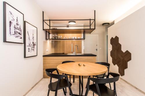 jadalnia z drewnianym stołem i czarnymi krzesłami w obiekcie Super-Apartamenty Exclusive w Poznaniu
