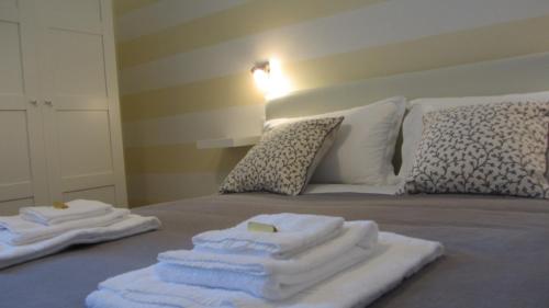 zwei Stapel Handtücher auf dem Bett in der Unterkunft The Old Station Rooms in La Spezia