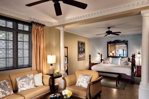 a bedroom with a bed and a couch and chairs at Half Moon in Montego Bay