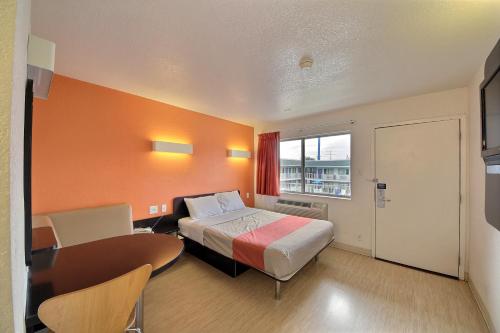 a hotel room with a bed and a table and a desk at Motel 6-San Marcos, TX in San Marcos