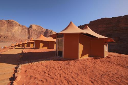a row of huts in the desert at Memories Aicha Luxury Camp in Wadi Rum