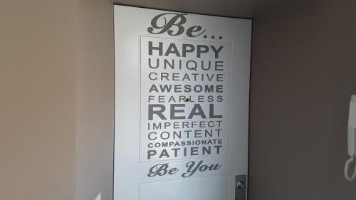 a sign on a door that says be happy unique creative awesome fearless real impactent at HaPPy InnSide, Free Parking, Self check-in 7x24h, AC in Vilnius