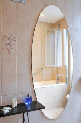 a bathroom with a mirror and a bath tub at Hotel Eden Montmartre in Paris